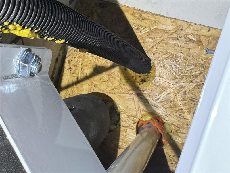 Bild på felaktig brandtätning bakom plywood.